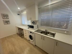 a kitchen with a sink and a microwave at Birkdale Granny Flat in Birkdale