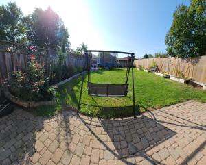 a swing in a yard next to a fence at Togather Time,5 minutes to HYW 401 in Oshawa