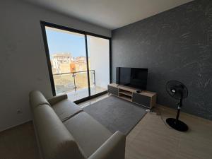 a living room with a couch and a flat screen tv at Apartamento Teixeira 2 in Espargos