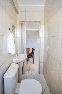 a white bathroom with a toilet and a sink at Hotel Santo Amaro - 700 m do Metrô Largo Treze, 13 Min do Autódromo de Interlagos e 7 Min do Transamérica Expo Center in Sao Paulo