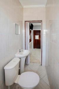 a white bathroom with a toilet and a sink at Hotel Santo Amaro - 700 m do Metrô Largo Treze, 13 Min do Autódromo de Interlagos e 7 Min do Transamérica Expo Center in Sao Paulo