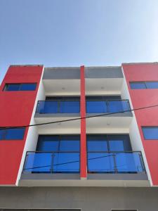a red and white building with blue windows at Apartamento Teixeira 2 in Espargos