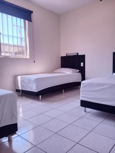 a room with two beds and a window at Apto Completo Aparecida de Gyn in Aparecida de Goiânia