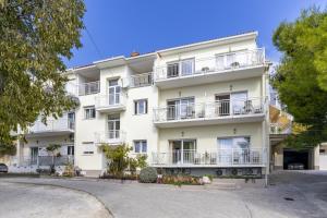 an apartment building with white balconies and trees at Apartments by the sea Duce, Omis - 946 in Duće