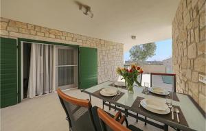 Amazing Apartment In Privlaka في Glavan: غرفة طعام مع طاولة وبعض الزهور عليها +8 صور
