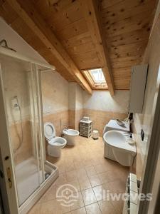a bathroom with two toilets and a shower and a sink at Appartamento Ad Navalia in Varazze