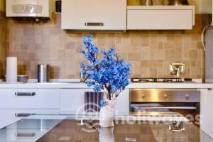 a vase with blue flowers sitting on a kitchen counter at Appartamento Ad Navalia in Varazze
