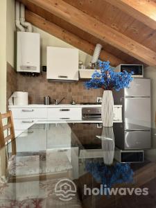a kitchen with a glass table with a vase of blue flowers at Appartamento Ad Navalia in Varazze
