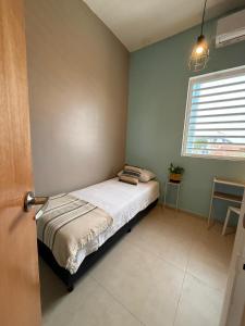 1 dormitorio pequeño con 1 cama en una habitación con ventana en La Guacamaya Azul en Willemstad, en Willemstad