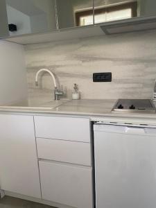 een witte keuken met een spoelbak en een fornuis bij Apartments by the sea Mali Losinj (Losinj) - 3444 in Veli Lošinj