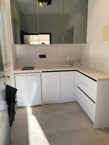 een witte keuken met een wastafel en een spiegel bij Apartments by the sea Mali Losinj (Losinj) - 3444 in Veli Lošinj +32 foto's