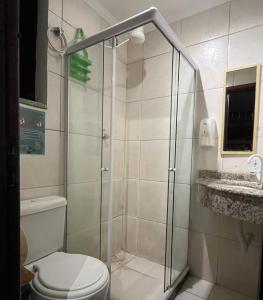 a bathroom with a shower with a toilet and a sink at Chamos Hostel Cultural in Arraial do Cabo