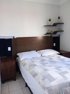 Un dormitorio con una cama grande con cabecero de madera. en Apto Completo Aparecida de Goiânia, en Aparecida de Goiania