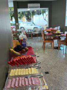 un bufé con carnes, quesos y frutas en Hotel Conceito, en Tareco