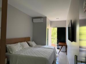 Un dormitorio con una cama en una habitación con ventana. en Hotel Conceito, en Tareco