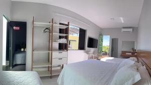 Un dormitorio con una cama blanca y una ventana. en Hotel Conceito, en Tareco