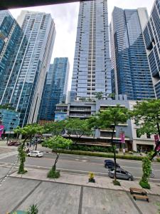 a city with tall buildings and a street with cars at Mysuites2go24K Parksuites T2 in Manila