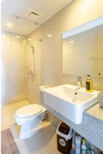 a bathroom with a white toilet and a sink at Mysuites2go24K Parksuites T2 in Manila