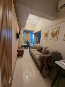 a living room with a couch and a table at Mysuites2go24K Parksuites T2 in Manila