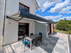 - une table et des chaises sur une terrasse avec un auvent dans l'établissement Maison rénovée au bord de la Saône avec terrasse et jardin - FR-1-583-463, à Rigny 10 autres photos