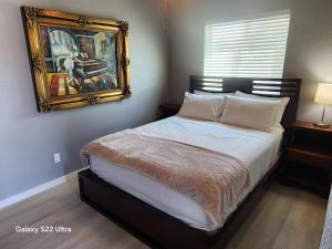 a bedroom with a bed with a painting on the wall at B2 Sunrise Springs Studio in Pahrump
