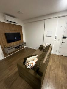 Una sala de estar con un sofá y un televisor de pantalla plana. en Home Experience prox USP, Facop e inst Mondelli, en Bauru