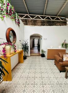 a living room with a couch and flowers on the wall at Hotel Bugambilia in Zimapán