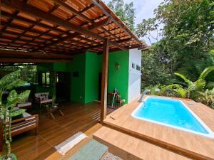 a swimming pool on a patio with a pergola at Flat de Irinha Moreré in Cairu
