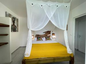 ein Schlafzimmer mit einem Himmelbett in der Unterkunft Tibo bas de villa NEUF accès mer in Deshaies