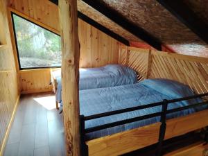 a bedroom in a log cabin with a bed at Cabañas Del Monte 1 in Melipeuco