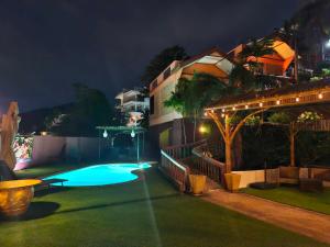 a swimming pool in a yard at night at The Cozy House in Karon Beach