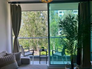 a living room with a large window with chairs and a plant at Confortable Apartamento in Barranquilla