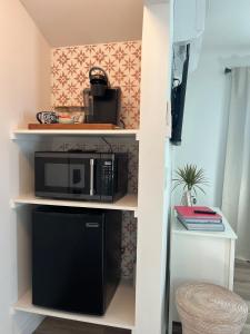 eine Mikrowelle auf einem Regal in einem Zimmer in der Unterkunft Charming Cozy Studio 5 Minutes from Sofi Stadium in Los Angeles