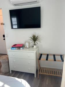 ein Schlafzimmer mit einer weißen Kommode mit einem Fernseher an der Wand in der Unterkunft Charming Cozy Studio 5 Minutes from Sofi Stadium in Los Angeles