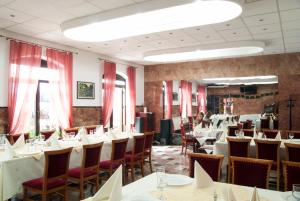 a dining room with tables and chairs and people in the background at Hotel Dacia in Lugoj