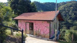 a small house with a painting on the side of it at Sonho na Serra Chalé 2 in Gonçalves