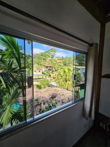 a window in a room with a view of a city at Flat rústico e aconchegante próximo a Paraty e Trindade in Paraty