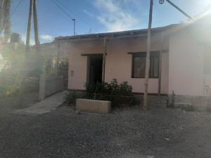 a small white house with a door in a yard at La torcaza in Purmamarca