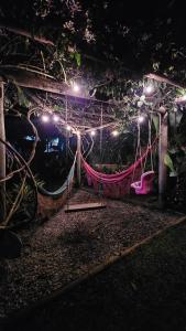 a room with a hammock and lights at night at Flat rústico e aconchegante próximo a Paraty e Trindade in Paraty +32 photos