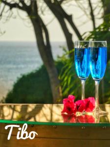 two glasses of blue wine sitting on top of a table at Tibo bas de villa NEUF accès mer in Deshaies