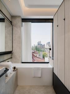 a bathroom with a large window and a bath tub at Shanghai Shang Ying CHAO Hotel in Shanghai +32 photos