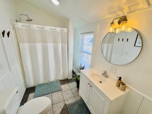 une salle de bain avec un lavabo, des toilettes et un miroir dans l'établissement Alwaves Family 3 Bedroom Beach Apartment, à Wildwood