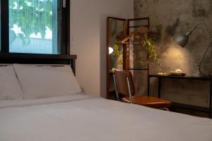 a bedroom with a bed and a chair and a window at Stay Breze Jamsil in Seoul