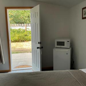 a bedroom with a microwave on top of a refrigerator at Cascade Motel in Oakridge