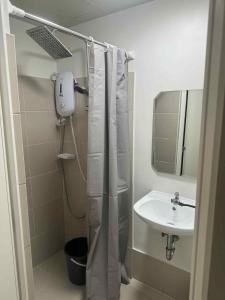 Un baño con cortina de ducha y lavabo. en Comfort Homey Studio with Fresh Mountain Air by Cherisia's Hideaway, en Baguio 17 fotos más