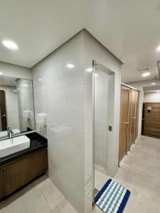 Un baño con ducha de cristal y lavabo. en Comfort Homey Studio with Fresh Mountain Air by Cherisia's Hideaway, en Baguio