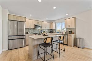 a kitchen with a refrigerator and two bar stools at 6BR Retreat with Playground Basketball & Sleeps 22 in Star