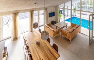 ein Wohnzimmer mit einem Tisch und einem Pool in der Unterkunft Nice Home In Nexø With Sauna in Bedegård