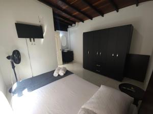 a bedroom with a bed and a black cabinet at Casa de Huéspedes Colibrí in Envigado +14 photos