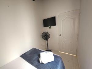 a room with a bed with a fan and a door at Casa de Huéspedes Colibrí in Envigado